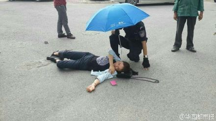 女子车祸受伤 警察单膝跪地为她撑伞(图)