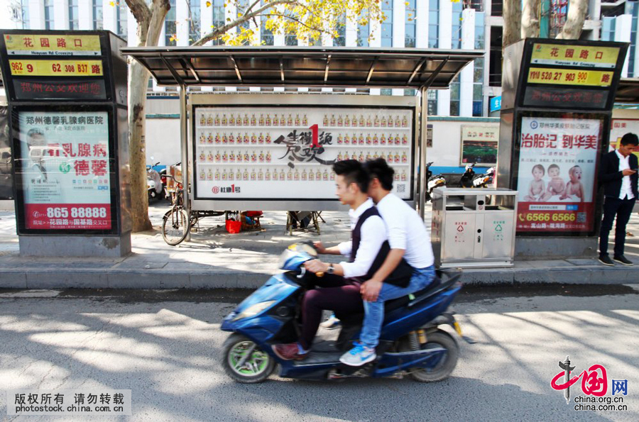 河南：郑州公交站广告牌内陈列百瓶白酒 引人注目[组图] 图片中国 中国网