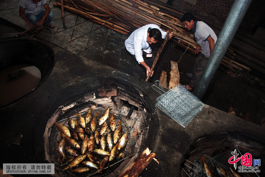  慢慢烘，缓缓烤。也有把活生生的鱼投入通红的火中烧烤，一直把鱼烧得焦黄滴油。中国网图片库 张晖摄