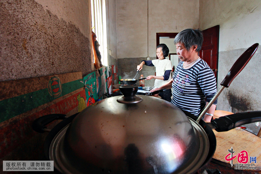  65歲孫秀青和隔壁租房陪讀的69歲夏玉鳳一起在公共廚房為孫兒們準備飯菜，他們的菜品都非常簡單，一個臘菜和一碗青菜。中國網圖片庫 曾勇攝