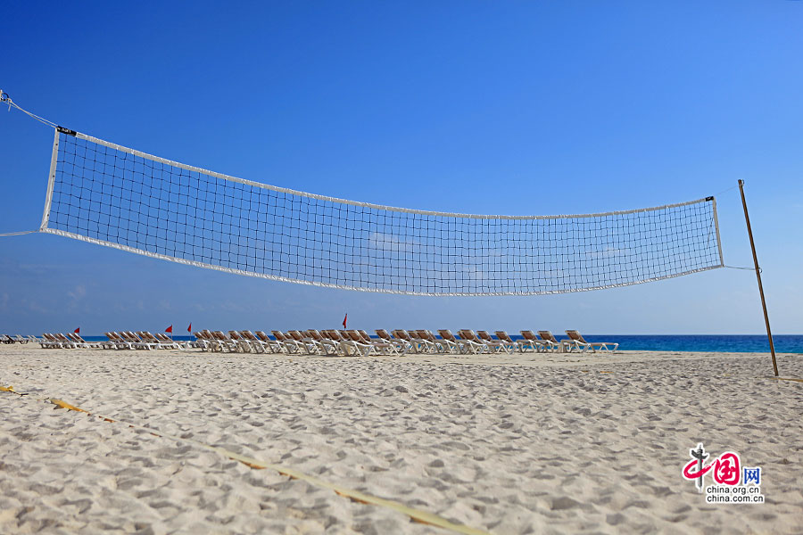 沙滩排球网与远处的太阳椅都成为这座天然游池最佳的伴侣