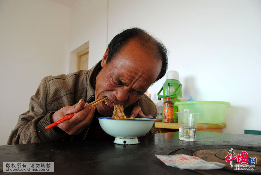  中午沒時間回家吃午飯的臧爾軍在煮麵條充饑。中國網圖片庫 楊文斌攝