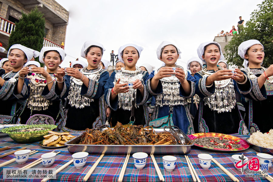 客人們到來，水族姑娘們在寨門擺好酒菜，唱著水歌，舉杯相迎。 中國網圖片庫 鄧飛攝
