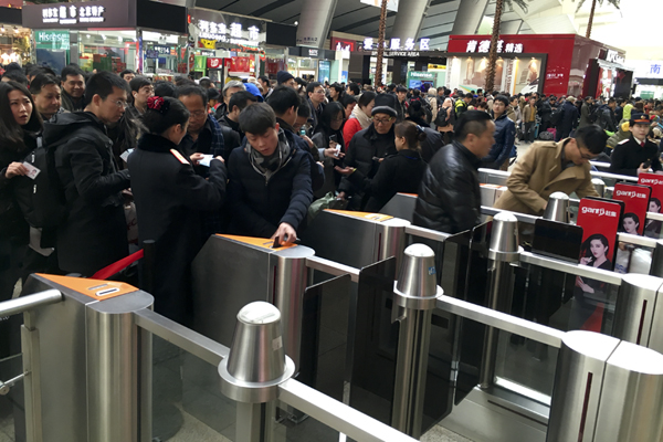 1月24日,春运首日,北京南站旅客在通过检票口进站乘车.