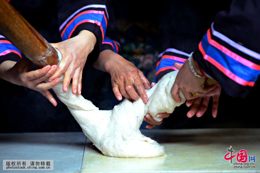 把舂好的糯米团放置在事先洗干净并涂上蜂蜡或茶油的桌板上，眼疾手巧的壮家妇女们就开始大显身手了。中国网图片库 黄旭胡摄 