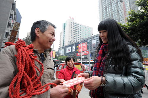 1月25日，重庆石桥铺街头一位“棒棒”接过“新年红包”。