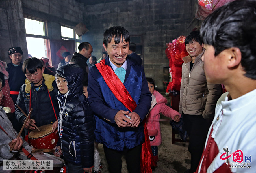 而新郎陈志良“披红”，就相当于办理了结婚登记手续。他和和村民一起见证了这一幸福的时刻。中国网图片库 张晖摄