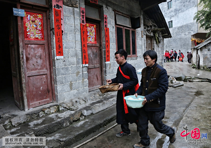 新郎家委派兩名小伙為寨上每一戶人送去一坨糯米飯、一塊肥肉，向寨鄰?fù)▓?bào)新娘已到家。中國(guó)網(wǎng)圖片庫(kù) 張暉攝