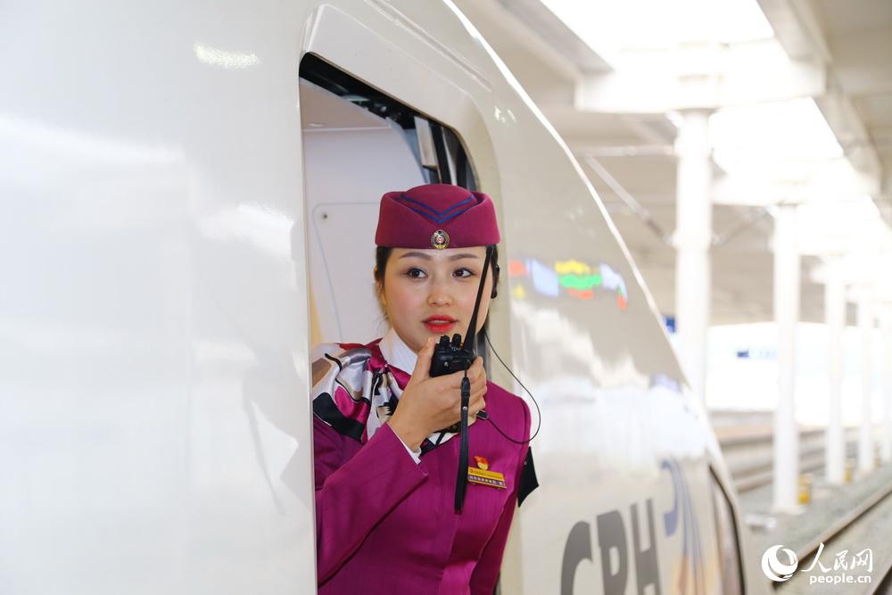 2016年2月2日，重慶，列車長高艷在檢查站臺上是否有乘客，協同司機做好關閉車門準備。