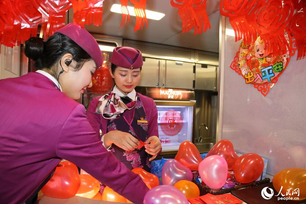 2016年2月2日，重慶，“動妹”馮丹和羅鋮一起吹氣球，佈置動車車廂。