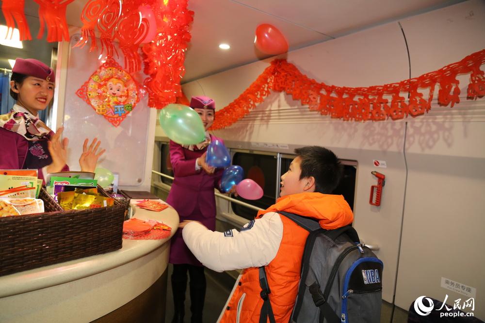 2016年2月2日，重慶，“動妹”馮丹和高艷和小旅客一起玩做搶氣球的遊戲。
