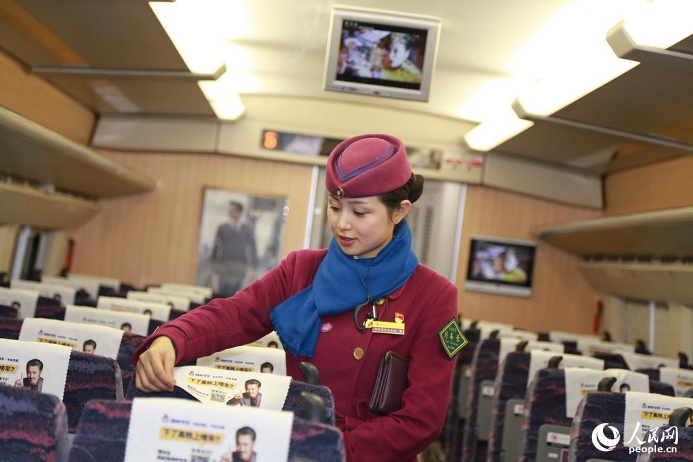 2016年2月2日，重慶，列車長高艷整理座椅上的頭巾片。