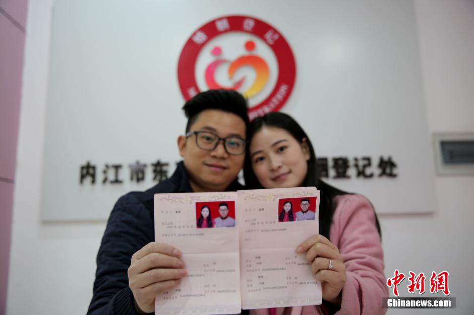 在四川省内江市东兴区婚姻登记处,一对新人在展示刚领取的结婚证书
