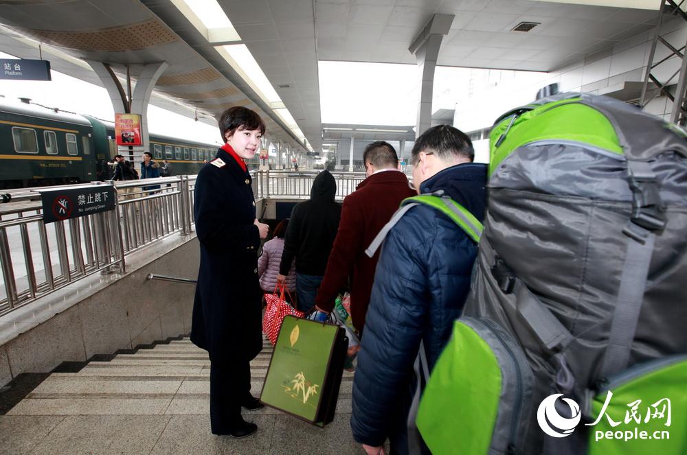2月25日10时许，陈雯雯正在引导乘车旅客有序通过地道。（胡志强 摄）