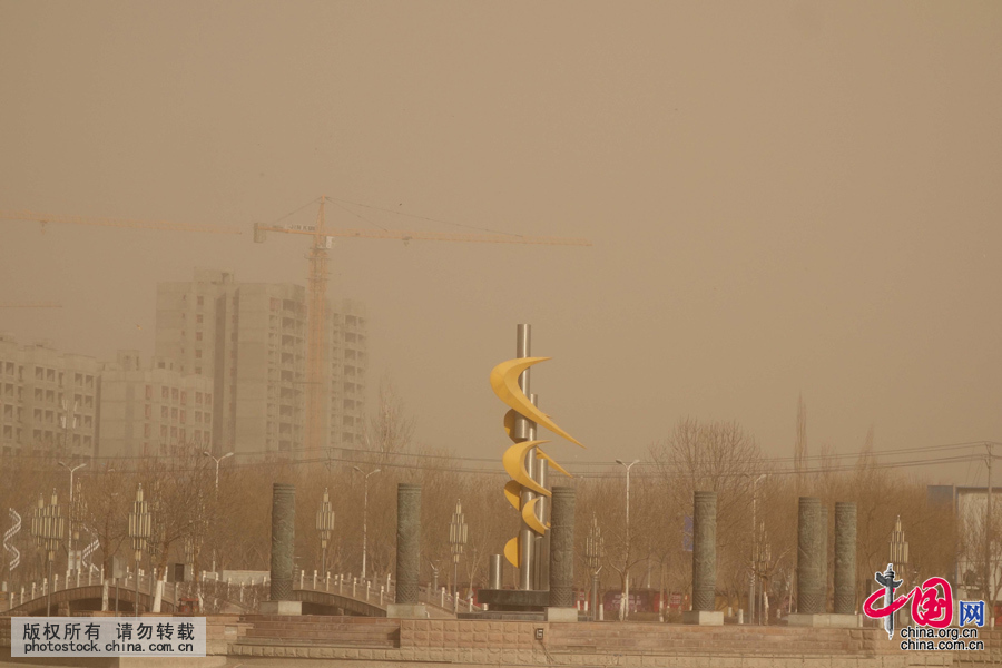 3月3日，吐鲁番市高昌区街头，大风刮起的沙尘将阳光遮挡，天空一片灰暗。中国网图片库 姜晓明摄