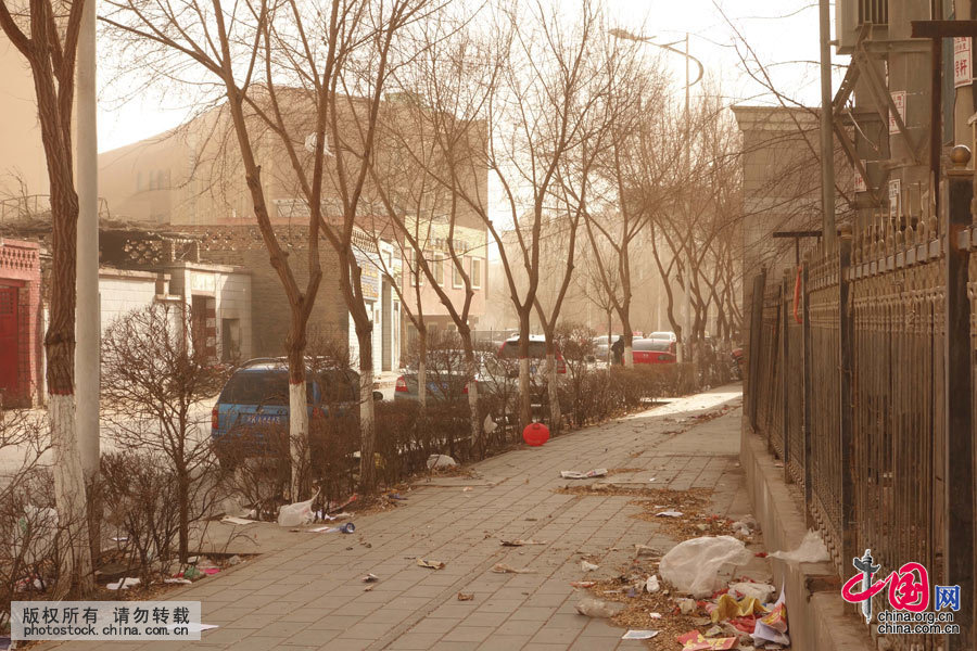 3月3日，吐鲁番市高昌区街头巷尾高挂的红灯笼和树叶、垃圾被大风刮的满地翻跑。中国网图片库 姜晓明摄