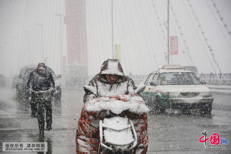 2016年3月2日，吉林省吉林市，市民在大雪纷飞的街头出行。中国网图片库 王凯冬 摄 