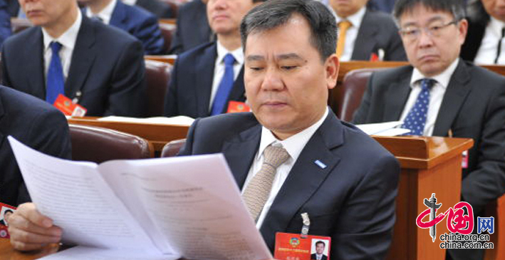 全国政协委员、苏宁控股集团董事长张近东认真听取会议报告。