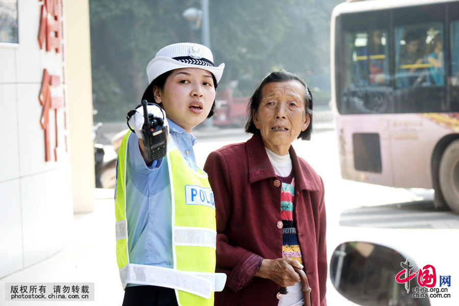 2013年10月11日，一位女警正在为老人指路。城市的车水马龙不可能把你淹没，迷路的老人虽然找不到回家的方向，但她一定能找到你，你抬手指路间那液下汗湿的警衫让人坚信你的忙碌，“ 闺女！谢谢你”。中国网图片库 陈自德摄