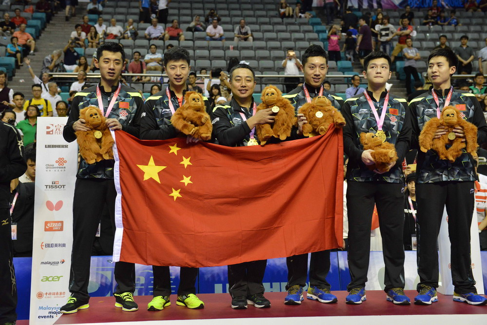 3月6日，中国队总教练刘国梁（左三），队员张继科、马龙、许昕、樊振东和方博（从左到右）在颁奖仪式上合影。新华社发（张纹综摄）