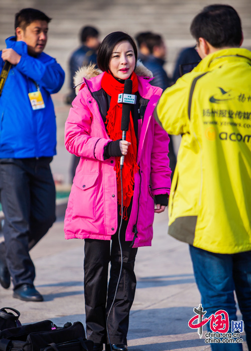 2015年3月5日，第十二屆全國人大第三次會議開幕會，一位身穿玫紅上衣的女記者在全國“兩會”報道中展現風采。中國網 鄭亮 攝