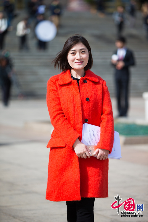 2016年3月5日，身穿紅色大衣的中國網女記者佟靜在人民大會堂前留影。中國網 鄭亮 攝
