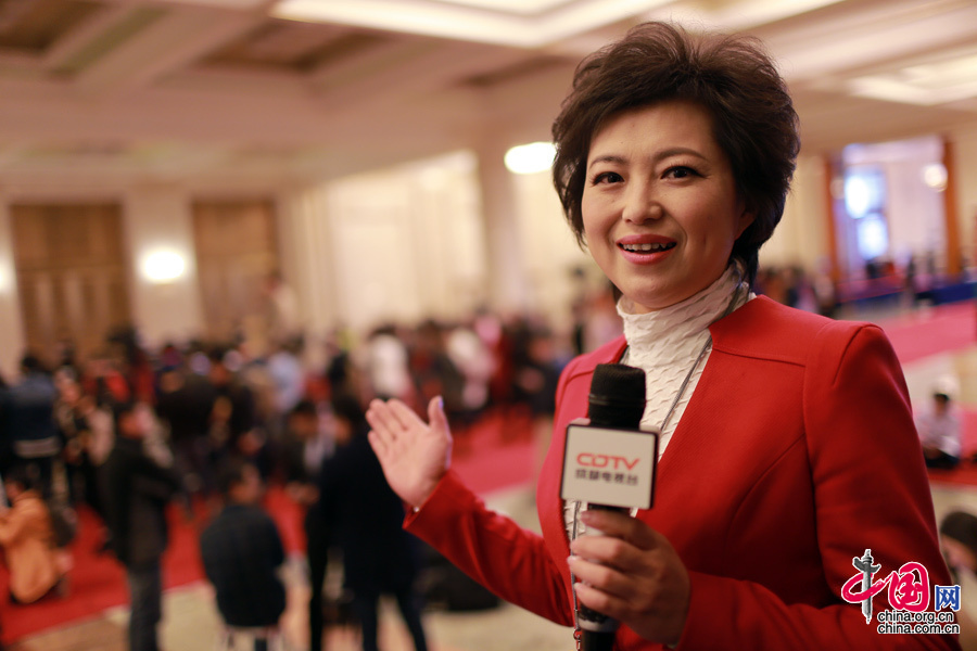  2015年3月5號，第十二屆全國人民代表大會第四次會議在人民大會堂開幕，身穿紅色正裝的成都電視臺女記者正在現場直播。中國網 楊佳 攝