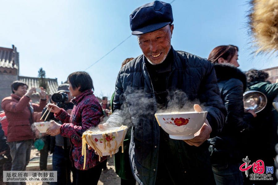 3月10日，河南省安陽縣水冶鎮阜城附近的白龍潭廟會上，2000人同吃“大鍋飯”（湯麵條），場面宏大，讓人嘆為觀止。中國網圖片庫 王子瑞 攝