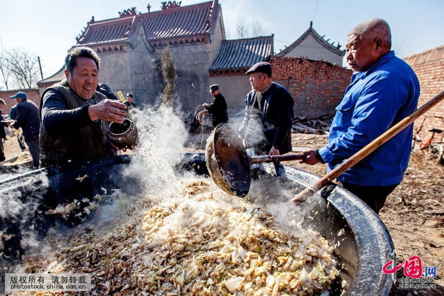 2016年3月10日，河南省安陽縣水冶鎮阜城附近的白龍潭廟會上，“大鍋飯”（湯麵條）廚師在炒菜。中國網圖片庫 王子瑞 攝