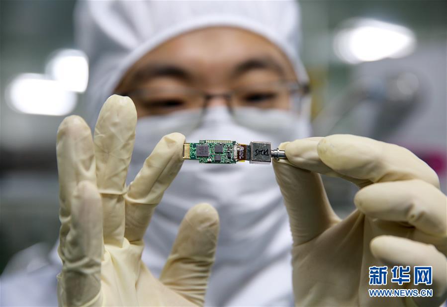 2015年11月7日，一名研究人员在位于西安的实验室内向记者展示光子集成芯片。