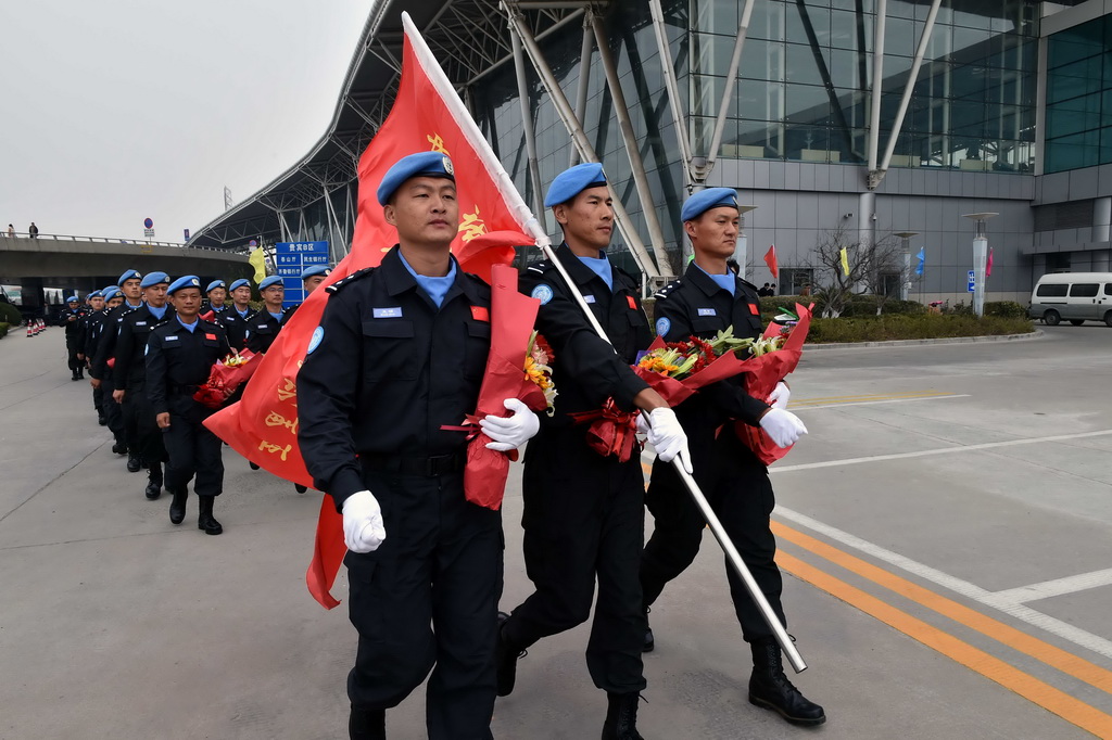 3月12日，維和警察防暴隊員列隊走出濟南遙墻國際機場。 新華社記者朱崢攝