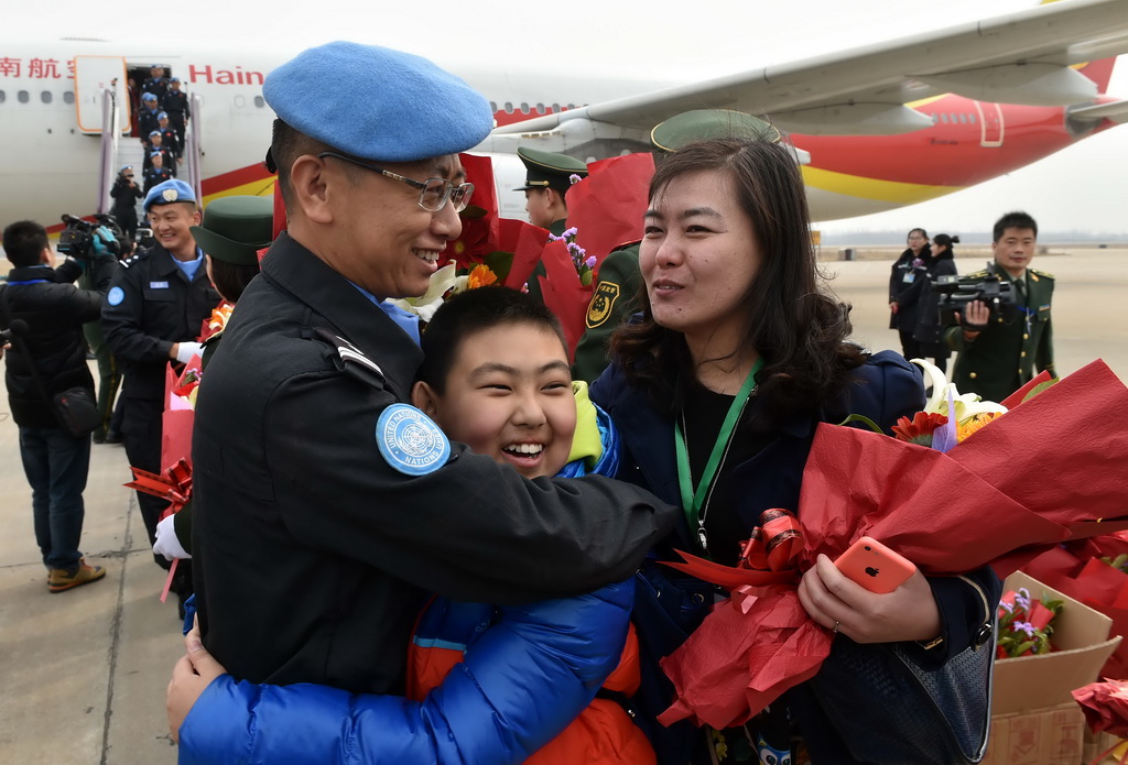 3月12日，維和警察防暴隊員趙金永和前來迎接的妻兒相擁。 新華社記者朱崢攝
