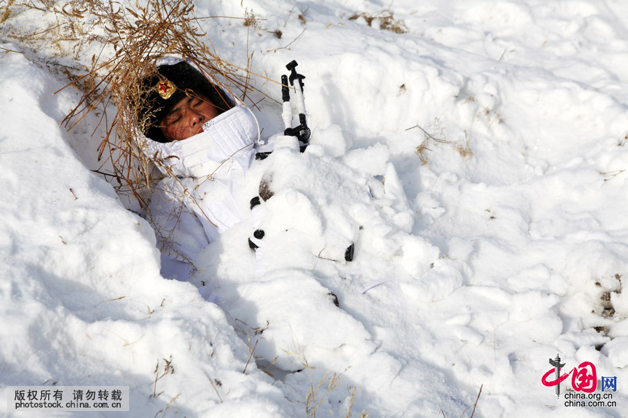  2015年2月3日，黑龍江黑河，一名年輕的狙擊手懷抱著狙擊槍全身覆蓋著積雪在剛剛能容下一個人的戰壕裏睡著了，睡眠對普通人來講是享受也許也是折磨，但對狙擊手來講，極寒條件下睡眠也是一種耐力訓練。中國網圖片庫 魏建順 攝