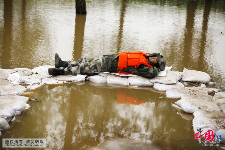 2014年8月18日，黑龍江黑河，一名戰士躺在洪水中的沙袋上睡著了，他説如果洪水再繼續漲水的話，他會第一個發現，當有人擔心他的安危時，他爽朗地説：“放心，俺從小就是在水里長大的！”。