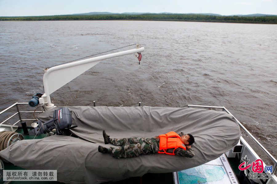  2015年6月5日，黑龍江黑河，經過為期兩天漫長的航行任務結束後，一名負責保障的戰士顧不得進休息室休息，而是順勢躺在船尾的快艇上“補覺”式地睡眠。