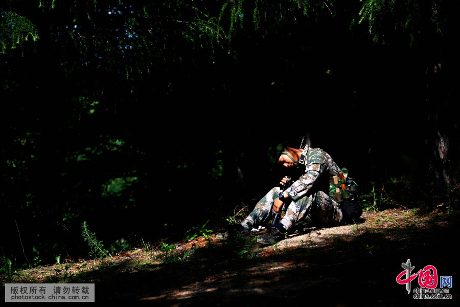 2014年6月11日，黑龍江黑河，由於連日來高強度的訓練，訓練間隙，一名戰士在樹蔭下懷抱著鋼槍睡著了。中國網圖片庫 魏建順 攝