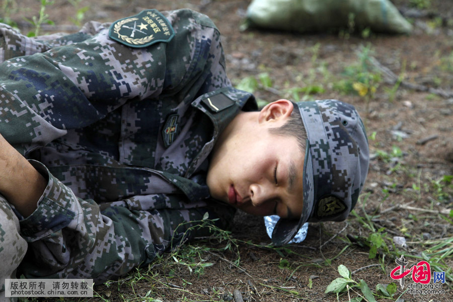 2013年8月7日，黑龍江黑河，抗洪大堤上，一名看似文弱的戰士躺在大堤上睡著了。中國網圖片庫 魏建順 攝