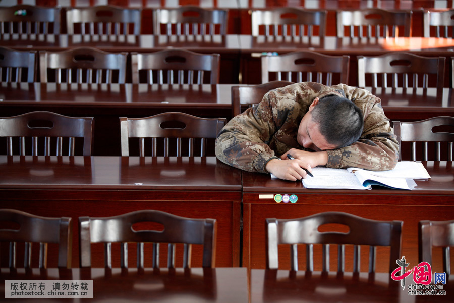 2015年10月21日，黑龍江黑河，一名剛剛入伍一個多月的新戰士獨自一人抄寫文案時，趴在桌子上睡著了。中國網圖片庫 魏建順 攝