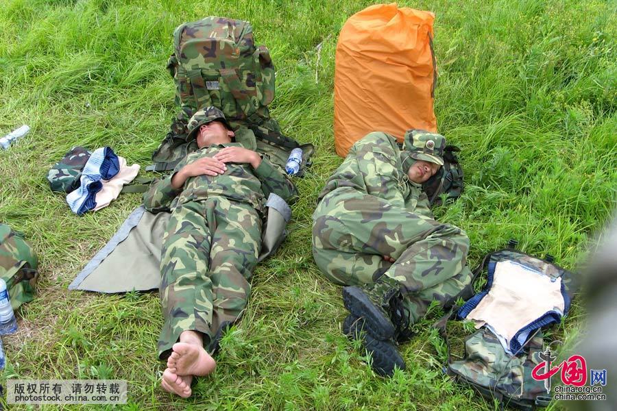  2007年7月7日，黑龍江黑河，茫茫烈日，頂著酷暑參加游泳訓練的戰士們訓練間隙，躺在草地上休息。中國網圖片庫 魏建順 攝