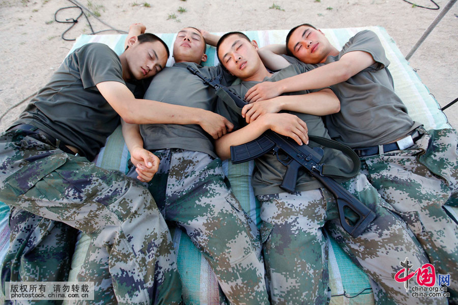  2015年8月13日，黑龍江黑河，訓練勞累一天的四名戰士在訓練場上簡單吃完晚餐後，“爭分奪秒”地和連隊其他戰士搶奪“地盤”休息，因為短暫的半個小時“調整時間”後，他們將繼續進行高強度的訓練。