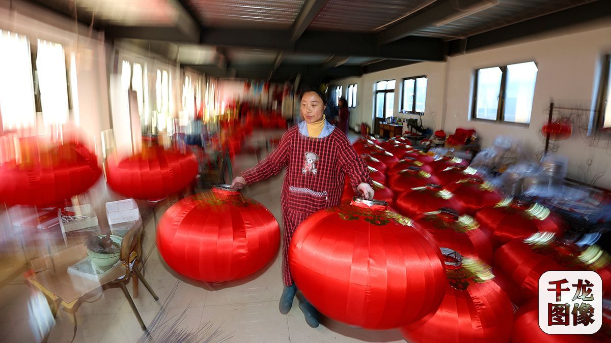 一名女工将刚刚完工的灯笼整齐的码在一旁的空地上3月9日摄）。千龙网记者 王悦摄