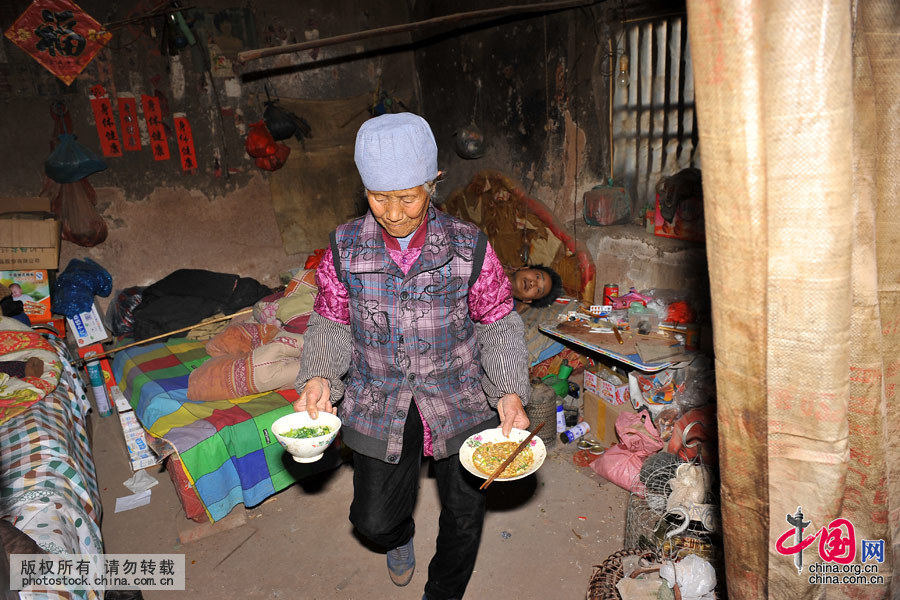 夏培英老人在照看兒子吃飯，每次都是看著兒子吃完後，她才自己一個人簡單的吃點。中國網圖片庫 劉明照 攝
