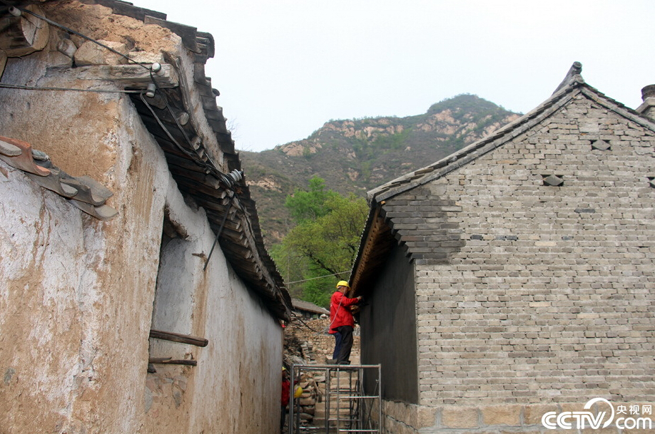  驼湾村正在进行农村面貌改造提升，一侧的土坯草房（左），与旁边青砖灰瓦的新居所（右）形成了鲜明的对比。村民们不出村，就能住进新家园。（央视网记者 郭城 摄影）