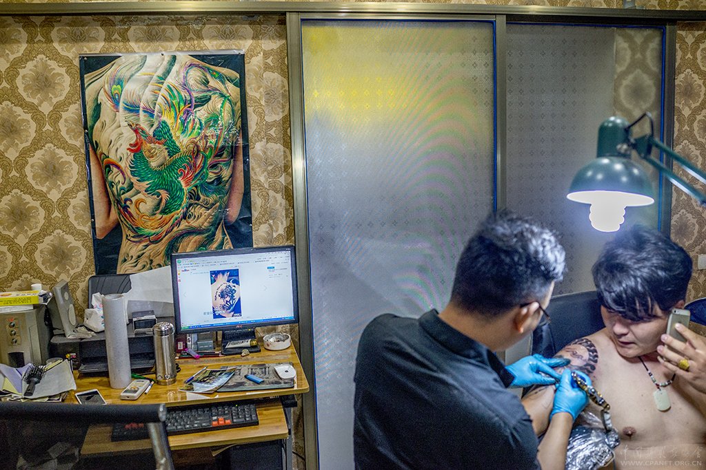 22、正在纹身的年轻人。(2015.1)