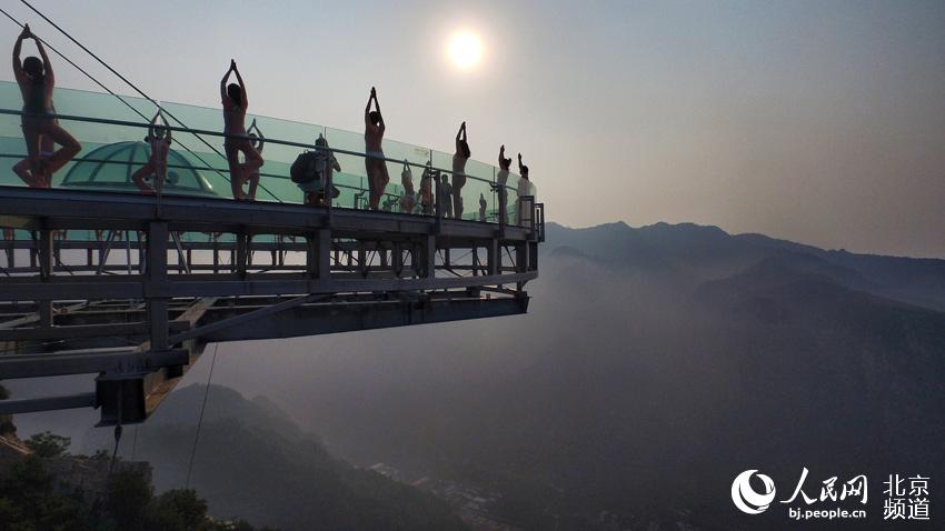 伴著清晨的旭日，瑜珈愛好者在玻璃觀景臺上練起了瑜珈。
