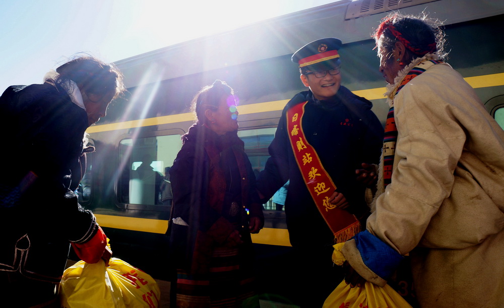 青藏铁路延长线拉日铁路日喀则火车站工作人员帮助乘客乘车(2016年1月