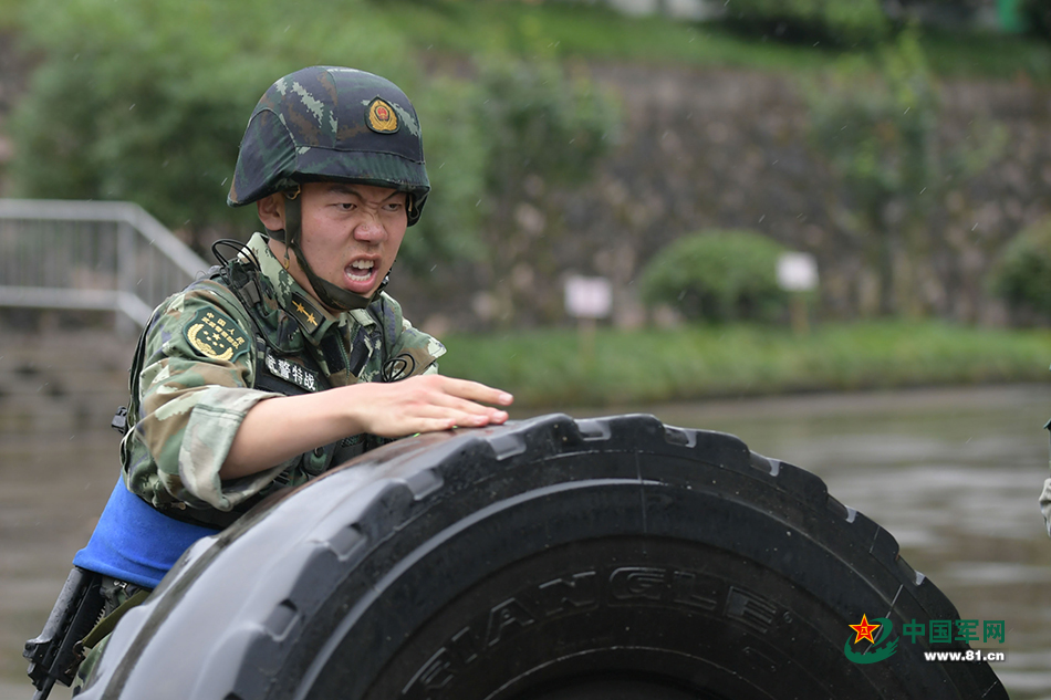 排长林海鹏在细雨中奋力翻轮胎.