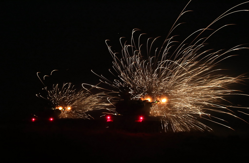 陆军第39集团军某红军旅炮兵团新型自行火炮进行夜间射击（2015年10月12日摄）。