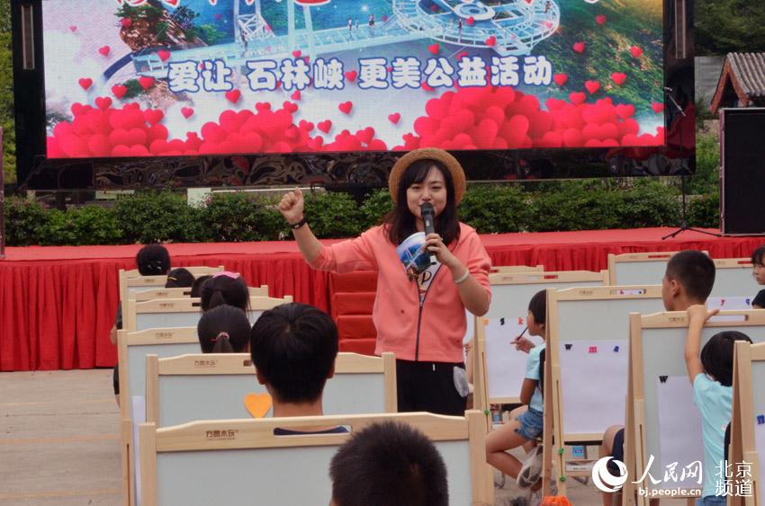 活动现场，中央人民广播电台《小喇叭》节目的著名少儿主持人春天姐姐与孩子们进行游戏互动。人民网尹星云 摄