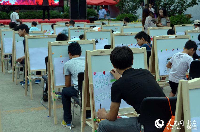 活动现场，北京太阳村的孩子们用画笔画出自己心中美好的生活和愿望。人民网尹星云 摄